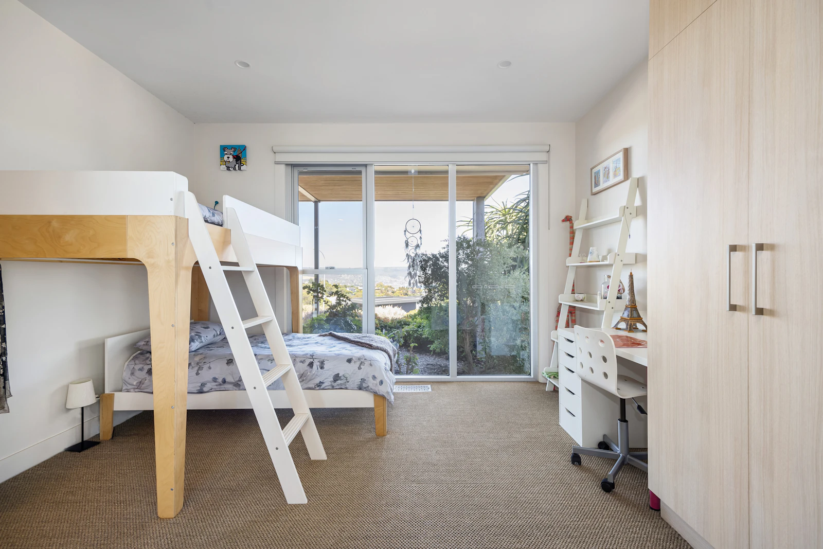 Lit superposé en bois clair avec échelle blanche dans une chambre d'enfant lumineuse