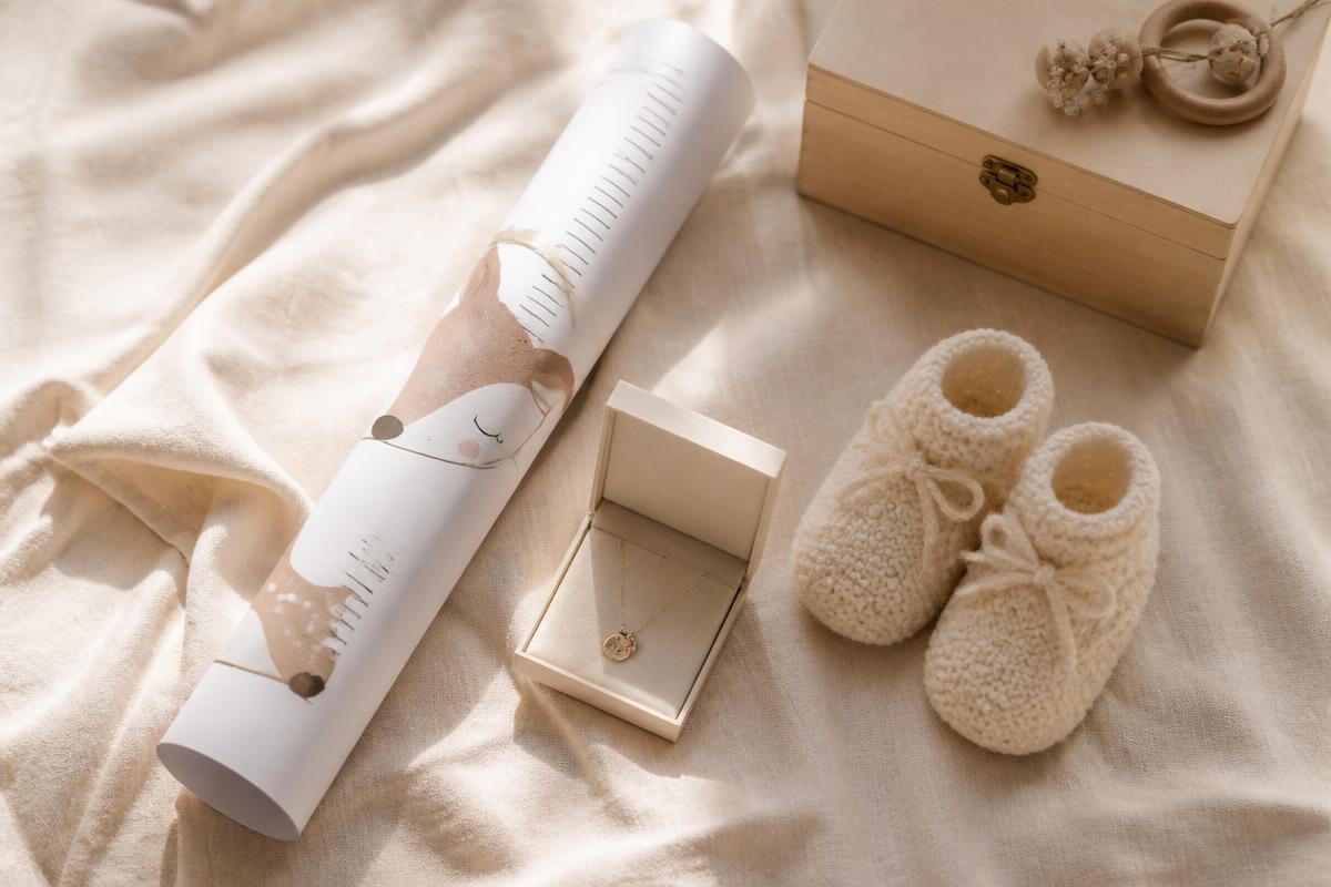 Cadeaux de naissance posés sur une couverture, dont une toise personnalisée en papier